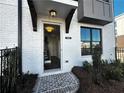 Welcoming entrance with stone pathway, dark wood accents, black trim windows, and white-painted brick at 508 Healy Dr # 70, Cumming, GA 30040