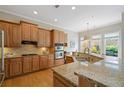 This spacious kitchen features wooden cabinets, stainless steel appliances, and granite countertops at 11945 Dancliff Trce, Alpharetta, GA 30009