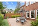 Enjoy outdoor living on this patio with black metal seating and a beautiful striped umbrella for shade at 11945 Dancliff Trce, Alpharetta, GA 30009