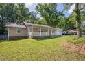 Exterior view of cozy home with green lawn and tree-lined surroundings at 1111 Louise Se Ct, Conyers, GA 30013