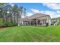 Expansive backyard featuring a covered patio, lush lawn, and a fence line surrounded by mature trees at 4216 Tattnall Run, Acworth, GA 30101