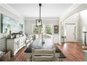 Bright dining room featuring a large window, a farmhouse table, and an arched entrance at 5015 Preservation Pointe Nw, Kennesaw, GA 30152
