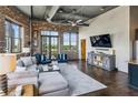 Loft-style living room with exposed brick, ductwork, hardwood floors, and a view to the outside at 3180 Mathieson Ne Dr # 1001, Atlanta, GA 30305