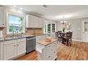 Bright eat-in kitchen with white cabinets, stainless steel appliances, and hardwood floors at 4140 Summit Dr, Marietta, GA 30068
