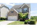 Charming two-story home featuring a brick and stone facade, a two-car garage, and a well-maintained lawn at 5888 Cobblestone Creek Cir, Mableton, GA 30126