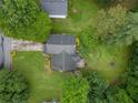 Aerial view of a home with a dark roof, surrounded by lush greenery and a well-maintained lawn at 4896 Muirwood Dr, Powder Springs, GA 30127