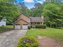 Charming two-story home featuring a well-manicured lawn, mature trees, and an attached two-car garage at 4896 Muirwood Dr, Powder Springs, GA 30127