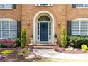 Close-up of home's entry featuring a blue door, arched entryway, and manicured landscaping at 93 Ridgetree Ln, Marietta, GA 30068