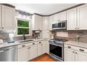 Updated kitchen features stainless steel appliances and stylish backsplash at 211 Caboose Ln, Woodstock, GA 30189