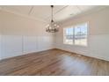 Elegant dining room featuring hardwood floors, wainscoting, large windows, and a chandelier at 257 Pinewood Dr, Covington, GA 30014