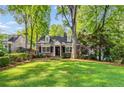 Beautiful brick home with black shutters, dormers, mature trees, and manicured lawn at 277 Alberta Ne Dr, Atlanta, GA 30305
