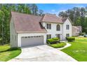 A two-story stucco home with an attached two-car garage and a well-kept lawn at 3060 Robertswood Dr, Powder Springs, GA 30127
