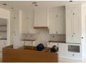 Spacious kitchen featuring custom white cabinetry and an island, awaiting countertops at 933 Mount Carmel Church Ln, Canton, GA 30114