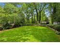 Expansive backyard featuring a lush green lawn, mature trees, and a small outbuilding at 1130 Angelo Ne Ct, Atlanta, GA 30319