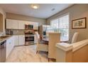 Bright kitchen with stainless steel appliances, white cabinets, marble flooring, and eat-in area at 1295 Kilmington Ct, Alpharetta, GA 30009