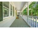 Inviting covered porch with a railing, painted wood flooring, and serene views of surrounding trees at 9955 Rivertown Rd, Fairburn, GA 30213