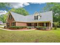 Attractive two-story brick home features a well-kept lawn and a welcoming front porch with white picket railing at 10 Hollow Ct, Covington, GA 30016