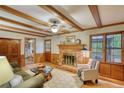 Cozy living room featuring a brick fireplace, exposed beam ceiling, and natural light at 3311 Creek Hollow Dr, Marietta, GA 30062