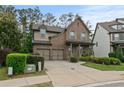Frontal view of a charming brick home with attached two-car garage and manicured lawn and shrubbery at 436 Barnett St, Woodstock, GA 30188