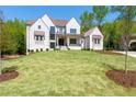 New construction featuring a lush lawn, freshly planted trees and complementary landscape design at 541 Londonberry Rd, Atlanta, GA 30327