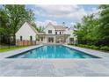 A luxurious backyard pool with stone surround, set against a pristine white home and lush landscaping at 541 Londonberry Rd, Atlanta, GA 30327