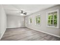 Bright living room featuring sleek floors, a ceiling fan and large windows with scenic outdoor views at 6549 Biscayne Way, Douglasville, GA 30135