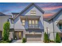 Charming two-story home featuring a balcony, front garden, and attached garage at sunset at 4046 Hazel Nut Ln, Atlanta, GA 30342