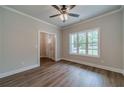 Bright living room with wood floors, large window, neutral walls, and a ceiling fan providing comfort at 1482 Alcovy Station Rd, Covington, GA 30014