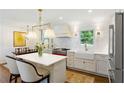 Stylish kitchen featuring white cabinets, a red range, marble countertops, stainless steel appliances, and pendant lighting at 3872 Francis Dr, Powder Springs, GA 30127
