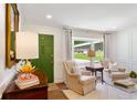 Bright and airy living room with large window, elegant furnishings, and green door at 3872 Francis Dr, Powder Springs, GA 30127
