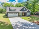 Charming single-story home featuring a well-manicured lawn, gray siding, and a two-car garage at 399 Chestnut St, Social Circle, GA 30025