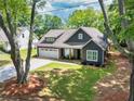 Attractive single-story house showcasing lush landscaping, gray siding, and an attached two-car garage at 399 Chestnut St, Social Circle, GA 30025
