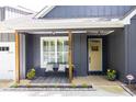 Welcoming front porch with seating, potted plants, and stylish decor leading to a yellow door at 399 Chestnut St, Social Circle, GA 30025