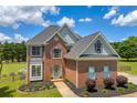 Beautiful two-story brick home with large windows and lush green lawn at 3135 Castlewood Dr, Loganville, GA 30052