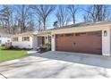 Inviting home featuring a spacious driveway leading to an attached garage with a meticulously maintained lawn at 4304 Lake Laurel Se Dr, Smyrna, GA 30082