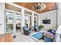 Inviting covered patio featuring wood ceiling, ceiling fan, comfortable seating, and decor at 212 Sessions St, Woodstock, GA 30188