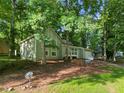 Quaint home nestled among mature trees boasts a charming exterior and landscaped front yard at 5248 Martins Crossing Rd, Stone Mountain, GA 30088