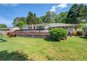 Spacious backyard featuring a large wooden deck, lush greenery, and shaded areas at 5327 David Cir, Covington, GA 30014