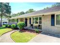Inviting brick home with a cozy front porch featuring chairs and manicured landscaping along the walkway at 5327 David Cir, Covington, GA 30014
