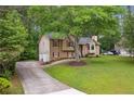 Charming split-level home with an attached garage, well-kept lawn, and tree-lined background at 685 Maplelake Dr, Acworth, GA 30101
