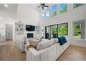 Bright living room boasts soaring ceilings, large windows, built-in shelving, fireplace, and hardwood floors at 17145 River Overlook Dr, Roswell, GA 30075