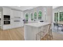 Bright, all-white kitchen with quartz counters, stainless steel appliances, and a breakfast bar perfect for casual dining at 6030 Sweet Creek Rd, Duluth, GA 30097