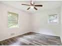 Cozy bedroom with two windows, neutral walls, ceiling fan and modern wood-look flooring at 8169 Kendrick Rd, Jonesboro, GA 30238