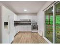 Functional kitchen with white cabinets and modern appliances, with sliding glass doors to backyard deck at 8169 Kendrick Rd, Jonesboro, GA 30238