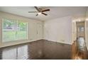 Bright living room featuring wood floors, a ceiling fan, and a large window offering natural light at 8169 Kendrick Rd, Jonesboro, GA 30238
