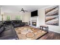 Inviting living room features a large leather sectional sofa, fireplace, ceiling fan, and stylish area rug at 3885 Weeping Willow Ln, Loganville, GA 30052