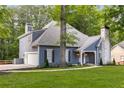 Beautiful exterior of a home with blue siding, an attached garage, and a stone chimney at 8260 Overview Ct, Roswell, GA 30076