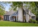 Home featuring blue siding and an elegant stone chimney at 8260 Overview Ct, Roswell, GA 30076
