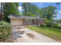 Cozy single-story home featuring a classic brick facade and a cracked concrete driveway at 1911 Rosewood Rd, Decatur, GA 30032