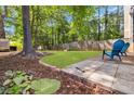 Landscaped backyard with a stone patio, mature trees, and a well-maintained lawn area at 1050 Hampton Hill Ct, Lawrenceville, GA 30044